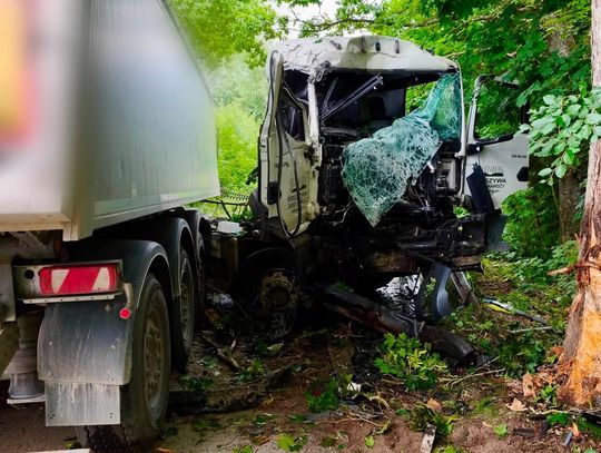 Ciężarówka uderzyła w drzewo i stanęła w poprzek drogi. Kierowca został uwięziony w kabinie