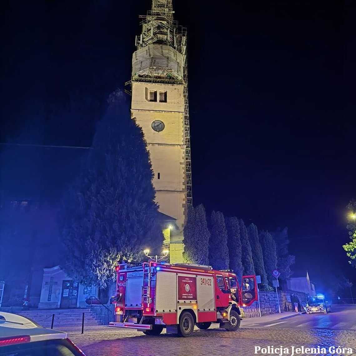 Koledzy weszli po rusztowaniu na wieżę kościoła. Jeden szedł po dobroci, drugi upierał się, że prędzej skoczy