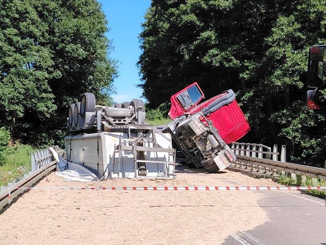 Naczepa wypięła się z ciągnika i przewróciła do góry nogami. Na jezdnię spadło 26 ton piasku [FOTO]